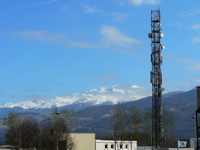 A radio antenna with a snowy mountain backdrop. 