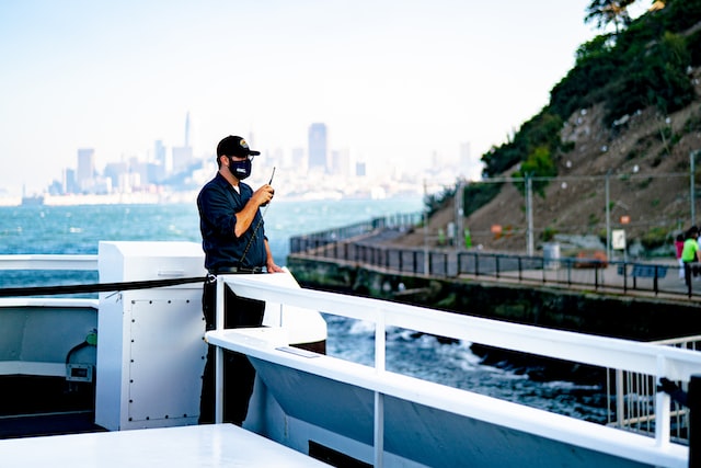 A man on a boat speaking through a two-way radio device 
