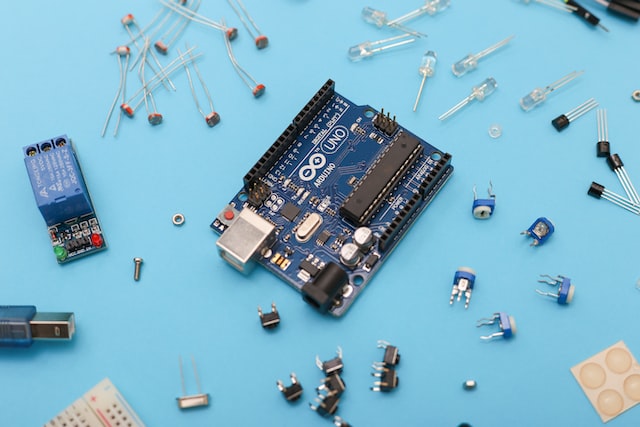 Blue and black circuit board with electronic parts on a blue surface